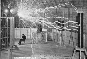 Tesla sitting amid his high voltage discharge apparatus - RF Cafe