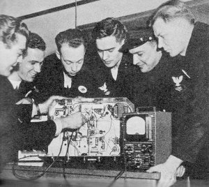 RF Cafe - Radio Amateurs in Navy Radio, CRT Sindelar, W8OOF, chief radio instructor at Radio Chicago, demonstrates the electronic voltmeter to students, April 1045 QST